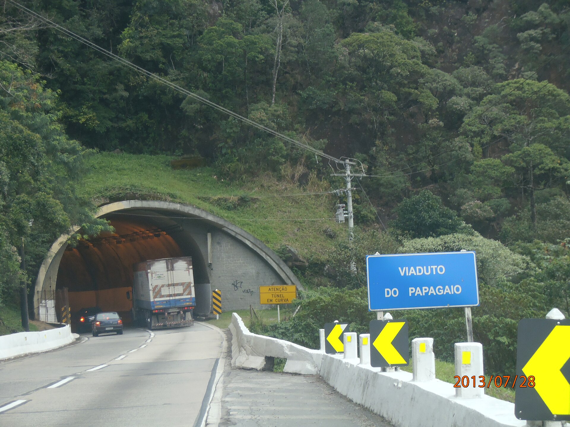 Veículos entrando no túnel do Viaduto do Papagaio, na BR-040, em Petrópolis, cercado pela Mata Atlântica.