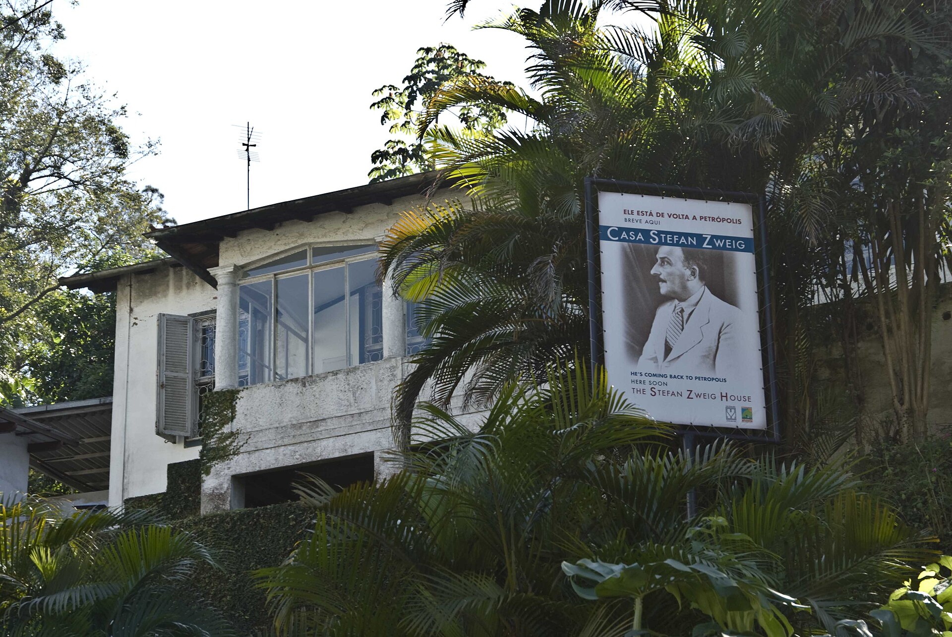 Fachada da Casa Stefan Zweig, em Petrópolis, cercada por vegetação e com a placa do museu.