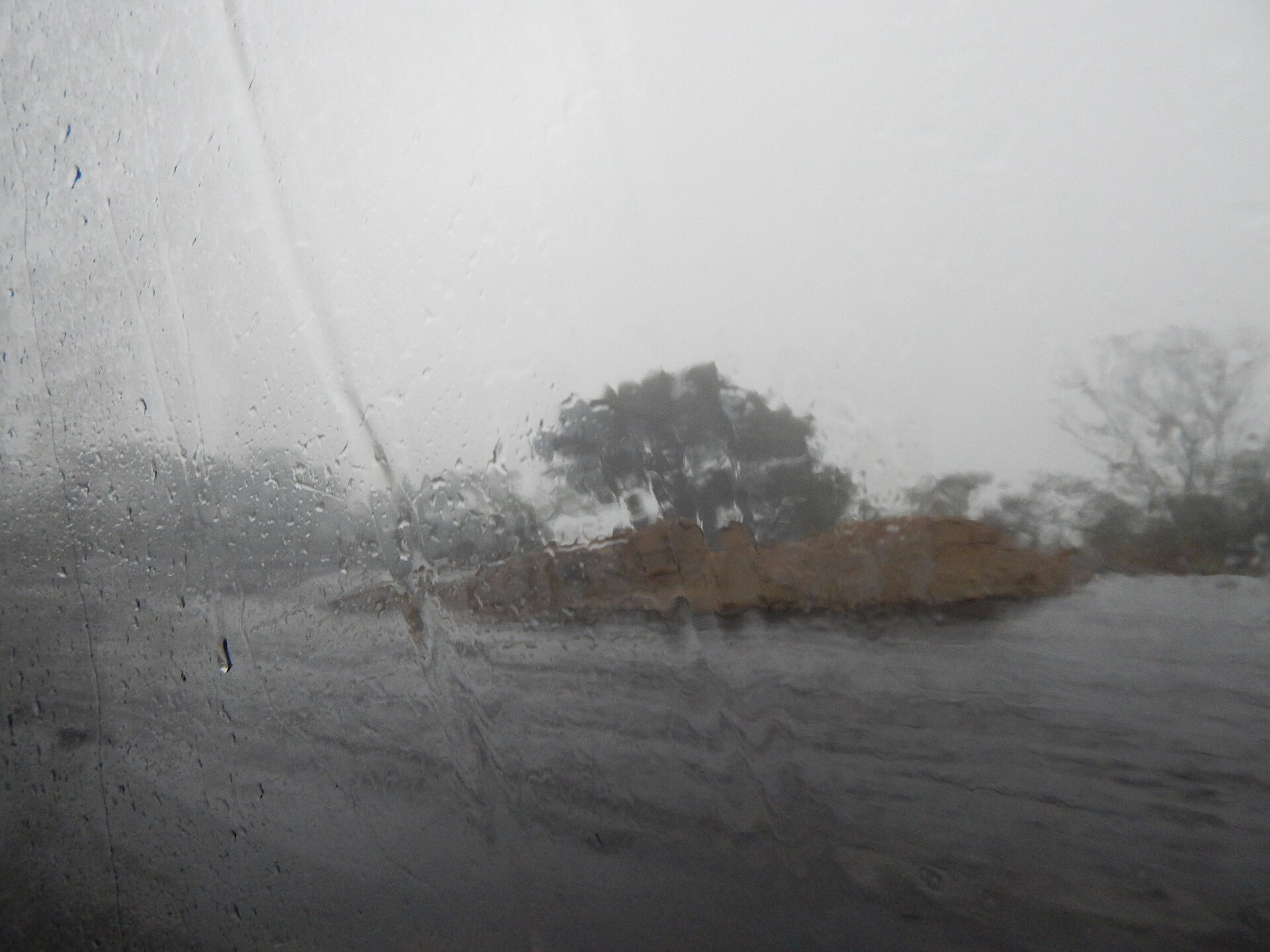 Chuva forte vista através do para-brisa em uma estrada de Petrópolis.