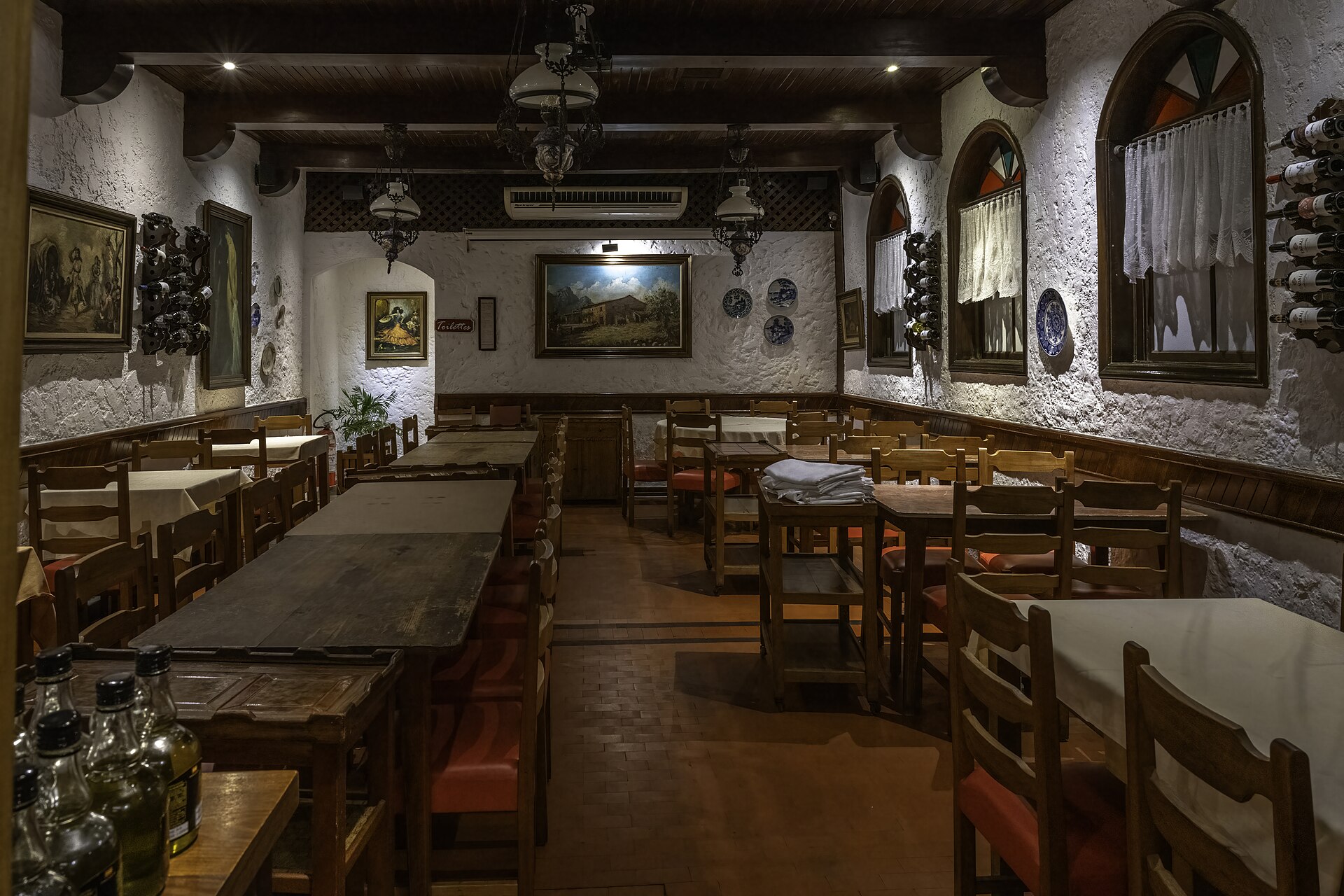Salão com mesas de madeira da Churrascaria Majórica, no Centro Histórico de Petrópolis.