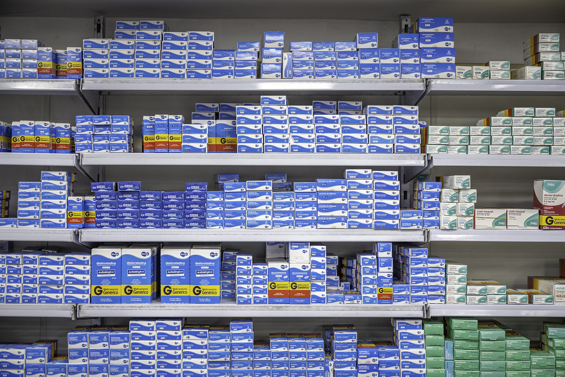 Prateleiras de uma farmácia em Petrópolis, com caixas de medicamentos organizadas por produto.