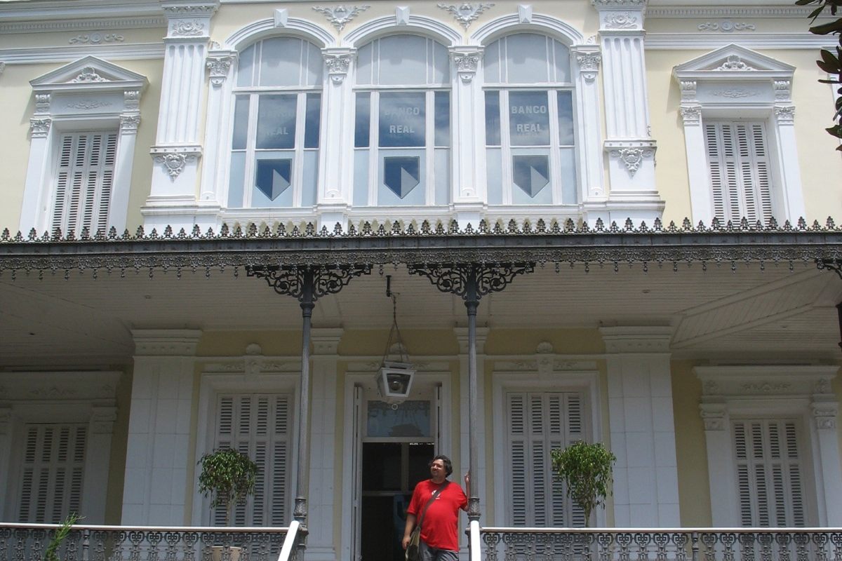 Fachada de um antigo edifício bancário em Petrópolis, com uma pessoa diante da entrada.