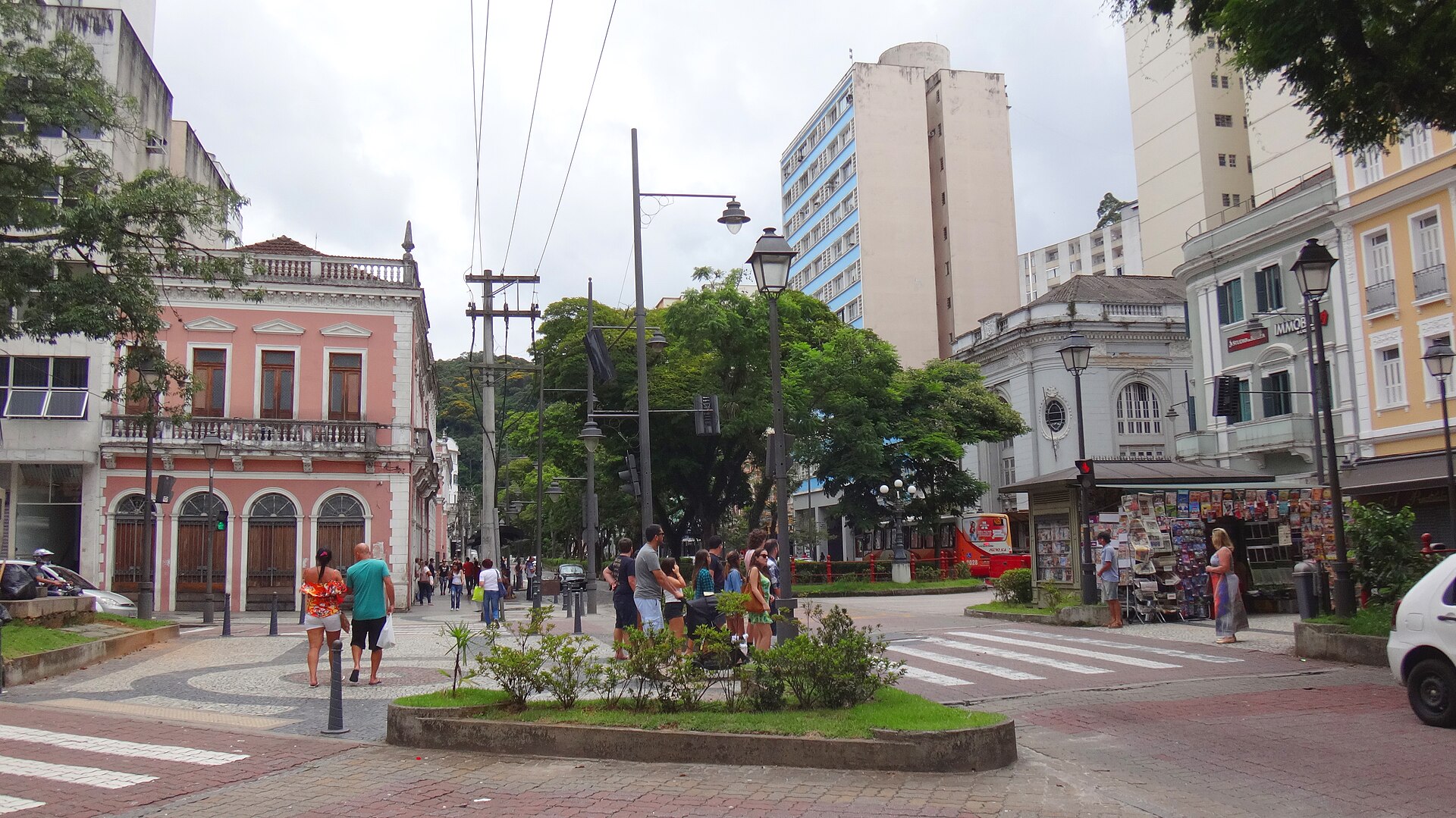 Rua do Imperador no Centro de Petrópolis, com pedestres, comércio, prédios históricos e transporte urbano.