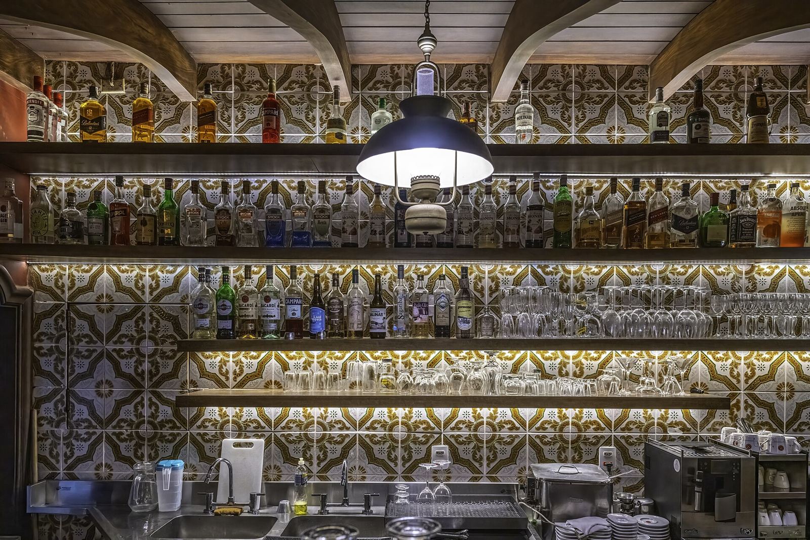 Bar da Churrascaria Majórica, em Petrópolis, com prateleiras de bebidas e copos.